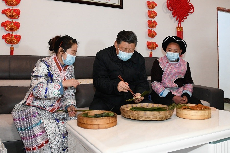 2021年2月3日下午，習(xí)近平在貴州畢節(jié)市黔西縣新仁苗族鄉(xiāng)化屋村苗族村民趙玉學(xué)家，同一家人邊聊家常邊制作當(dāng)?shù)貍鹘y(tǒng)節(jié)日食品黃粑。新華社記者 李學(xué)仁 攝