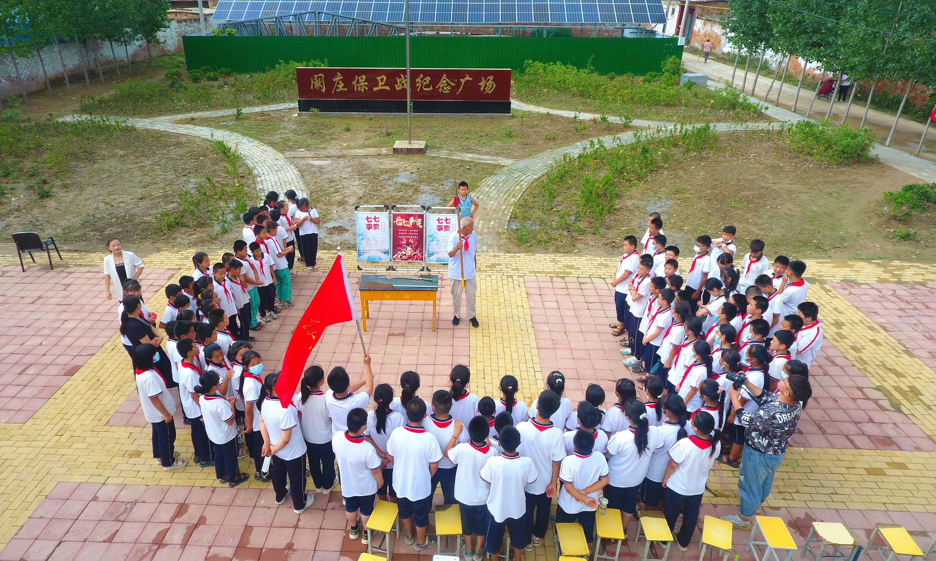 2022年7月6日，山東省聊城市，在茌平區(qū)菜屯鎮(zhèn)闞莊村的闞莊保衛(wèi)戰(zhàn)紀(jì)念廣場(chǎng)，闞莊保衛(wèi)戰(zhàn)親歷者王光木老人，為小學(xué)生們講述抗戰(zhàn)故事，展示大刀、長(zhǎng)矛。